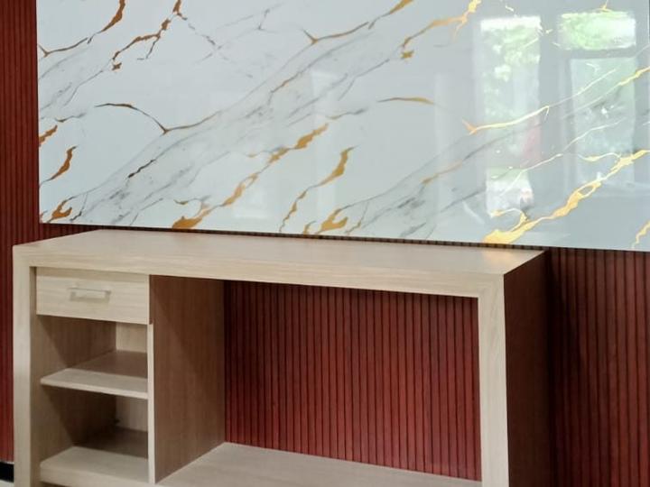 Backdrop marmer dengan panel dinding lis kayu dan meja TV